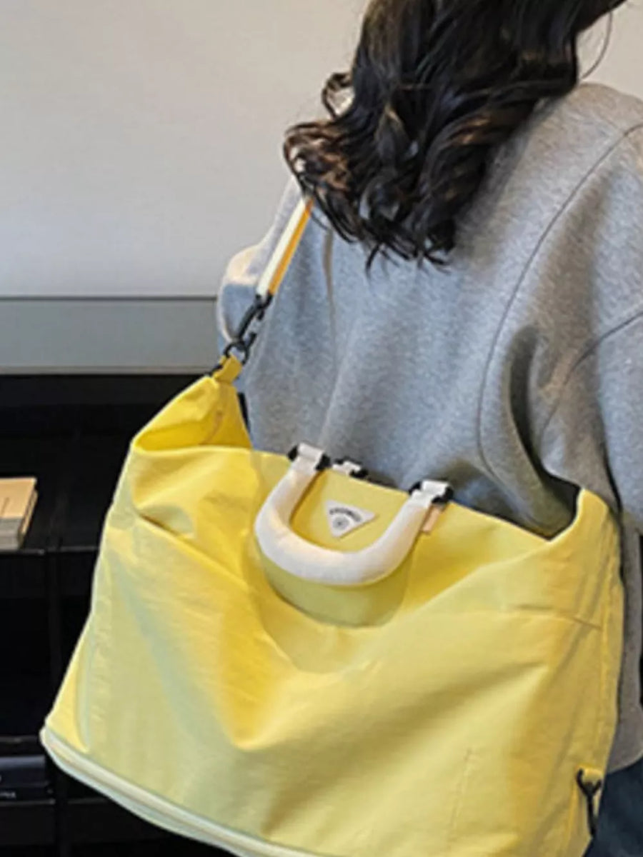 Yellow Oxford cloth duffel bag with white handle detail and adjustable strap.
