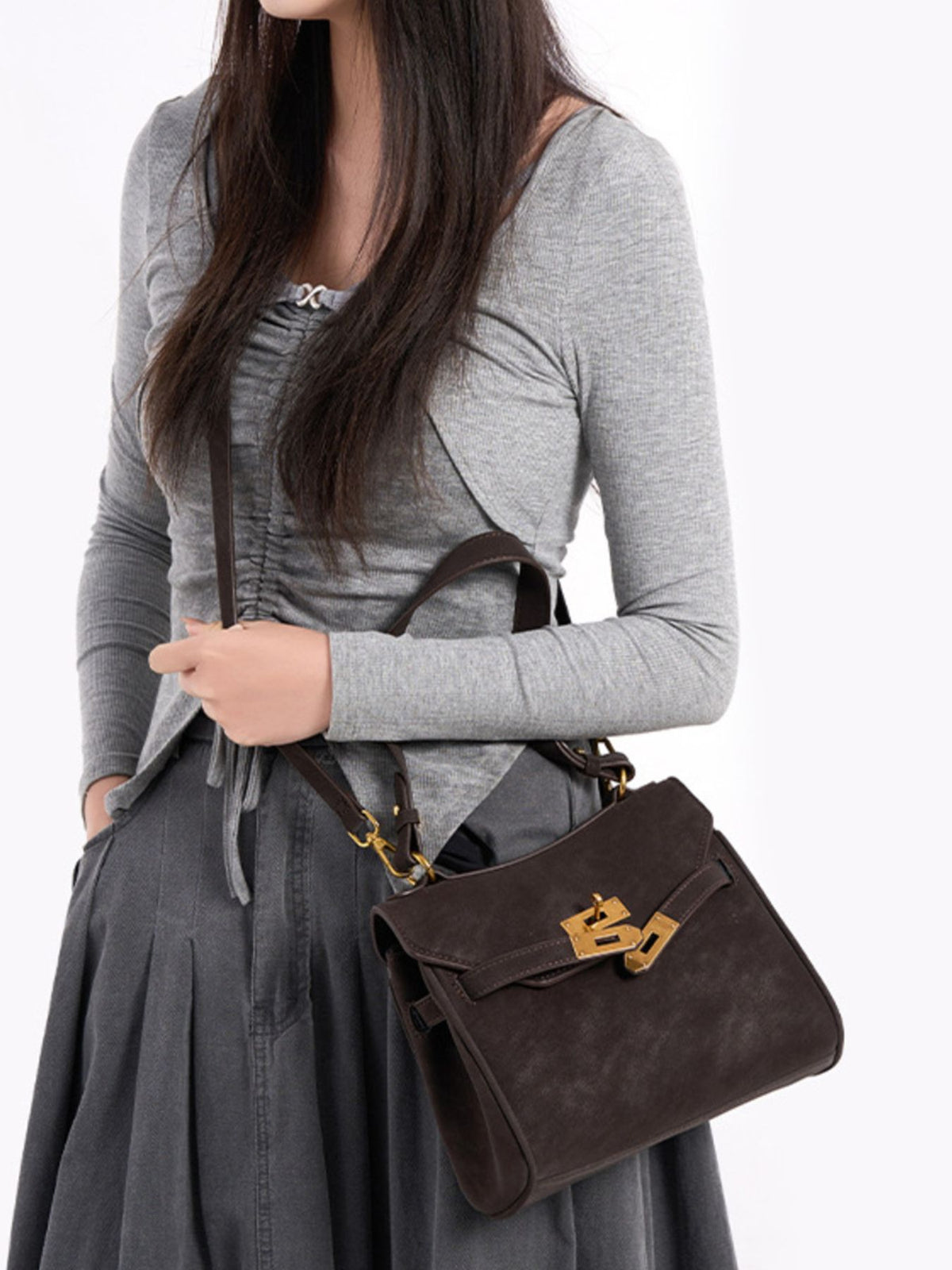 crossbody bag in dark brown featuring gold-tone hardware and boxy fit