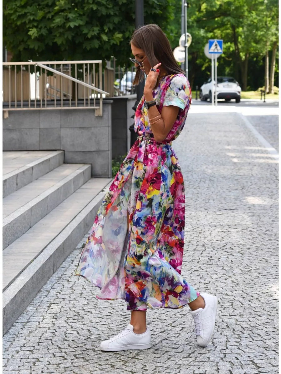Maxi dress with vibrant floral print, short sleeves, and a flowing skirt.