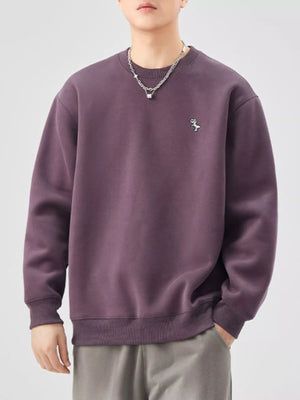 Purple long-sleeve sweatshirt with embroidered dinosaur detail and crew neck.