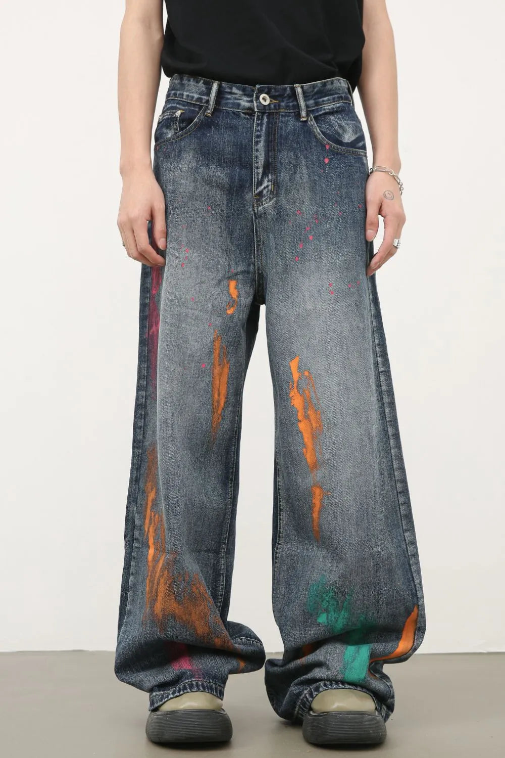 Painterly wide-leg denim jeans in medium wash with artistic paint splatters and wide leg cut.