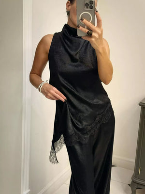 Black asymmetrical lace trim cami top with a mock neck and sleeveless design.