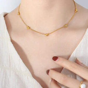 Gold chain necklace with small heart charms and zirconia accents