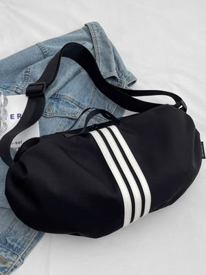Black crossbody bag with white stripes and adjustable strap