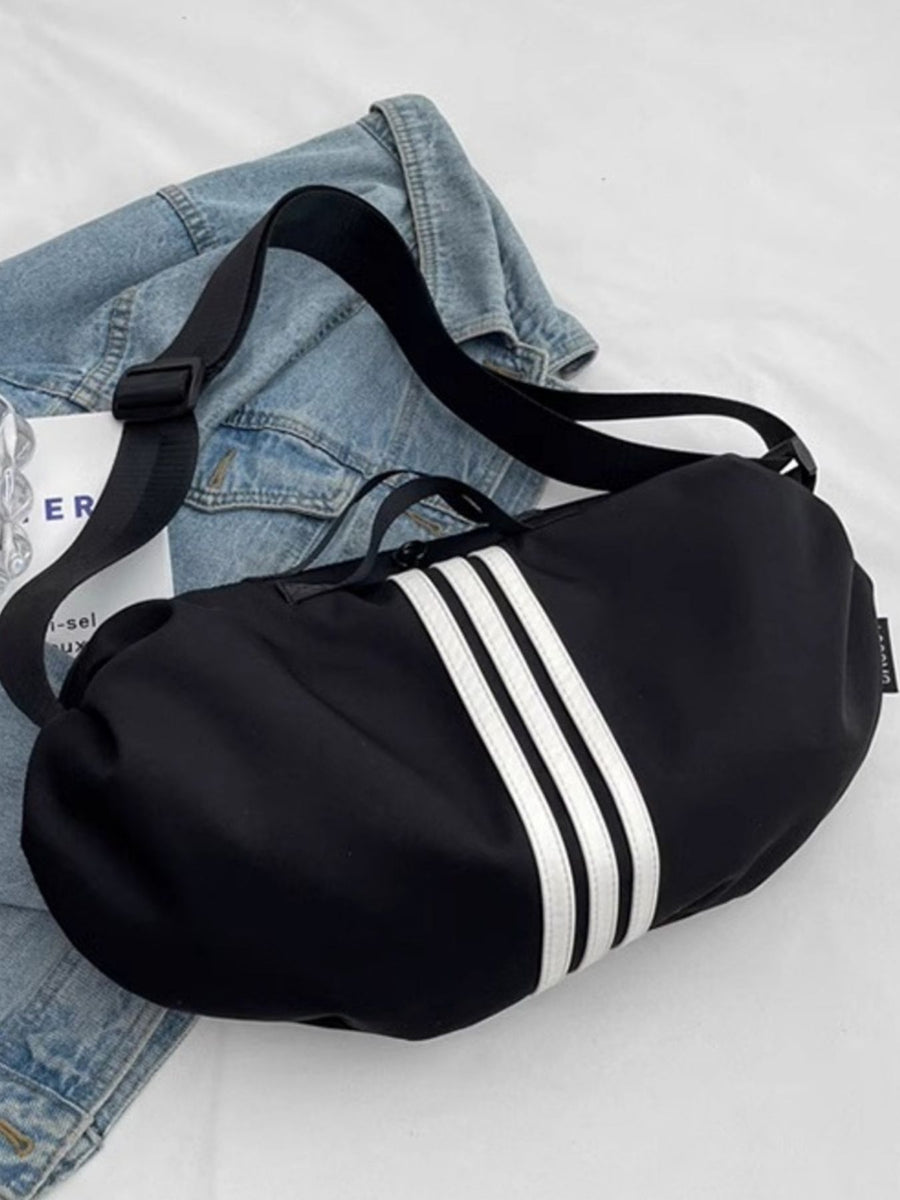 Black crossbody bag with white stripes and adjustable strap