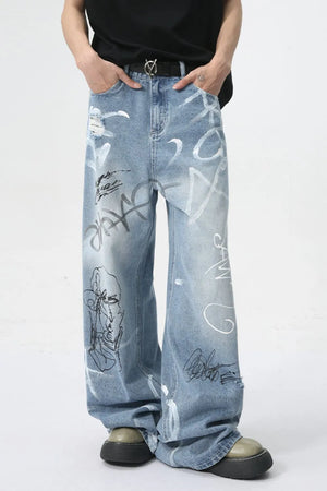 Graffiti art oversized denim trousers in medium wash with distressed details and abstract prints.