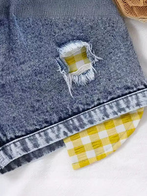 Denim shorts with yellow gingham patch detail and distressed accents.