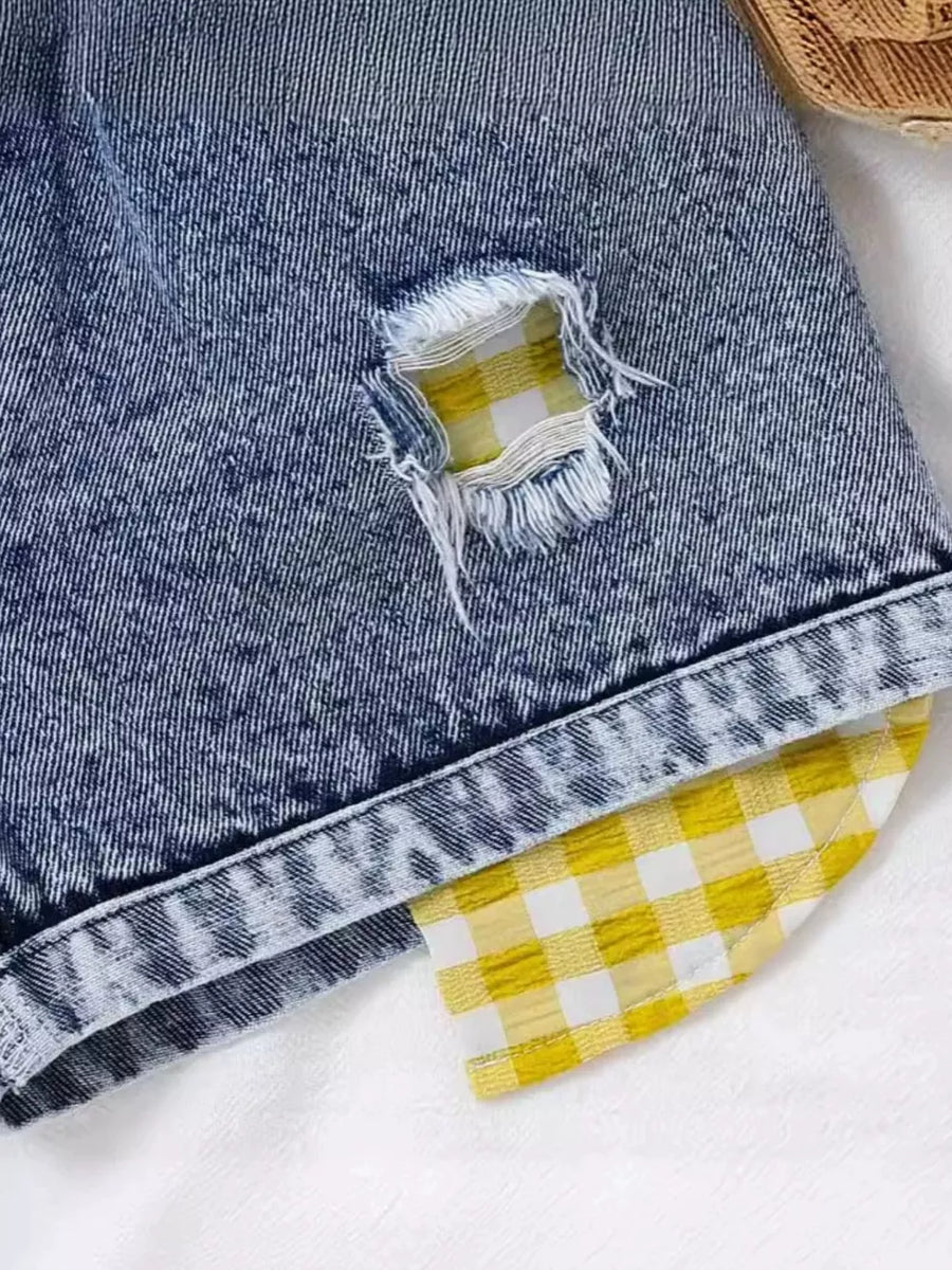 Denim shorts with yellow gingham patch detail and distressed accents.