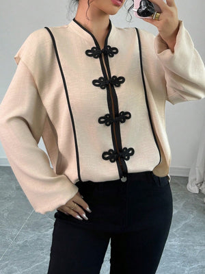 blouse in light beige featuring decorative button and relaxed fit