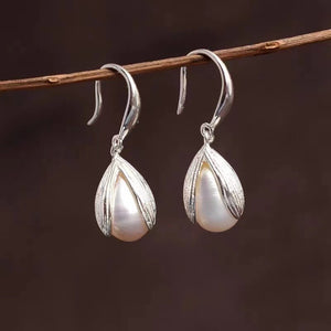 Lustrous pearl drop earrings with silver leaf-shaped settings.