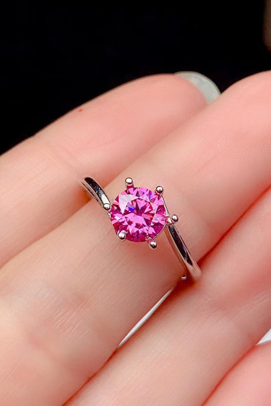 Radiant pink moissanite solitaire ring with a silver band.