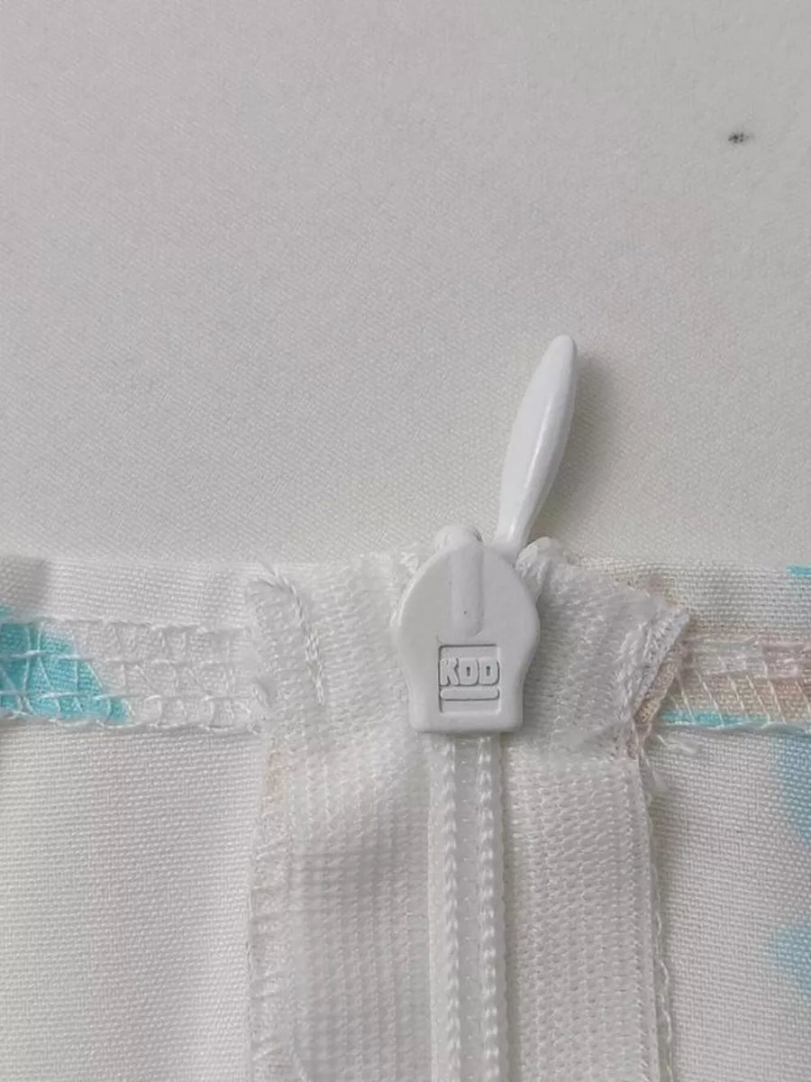 Floral maxi dress detail showing white zipper and pastel floral print.