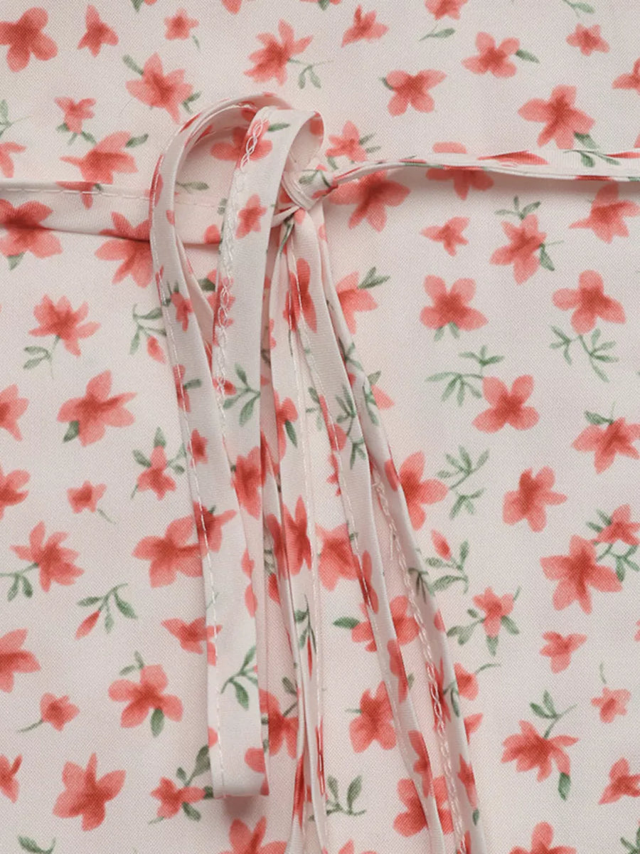 Floral mini dress with V-neck and puff sleeves, featuring a tie detail.