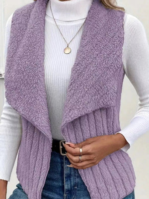 Purple fleece vest with open front and shawl collar, styled with a white turtleneck and jeans.
