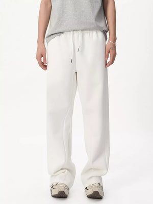 White relaxed fit sweatpants with adjustable drawstring waist and pockets.