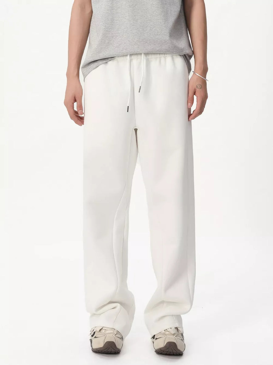 White relaxed fit sweatpants with adjustable drawstring waist and pockets.