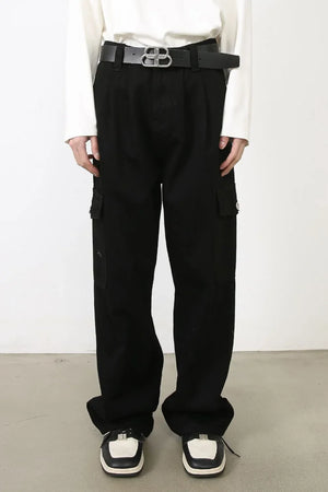 Black pleated denim cargo pants with multiple pockets and a relaxed fit.