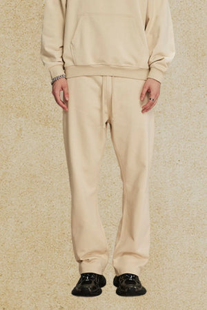 Relaxed fit tan joggers with drawstring waist and cuffed ankles.