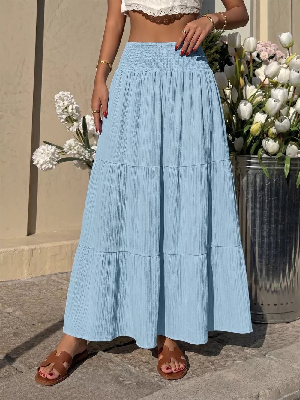 Blue smocked tiered maxi skirt with flowing elegance and textured fabric.
