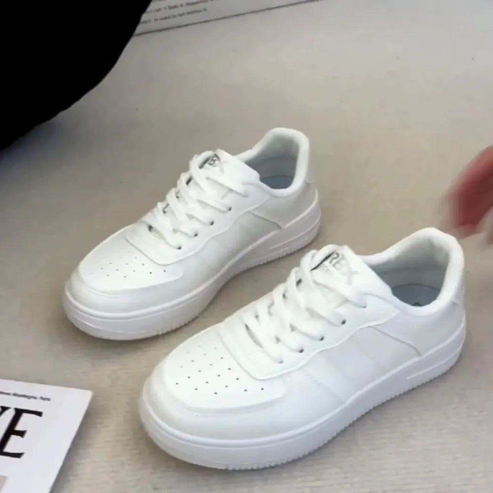 White minimalist platform sneakers with perforated toe boxes and lace-up closure.
