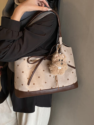 beige handbag featuring bow detail and polka dot