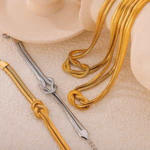 Gold and silver serpent knot cuff bracelets with snake chain detail