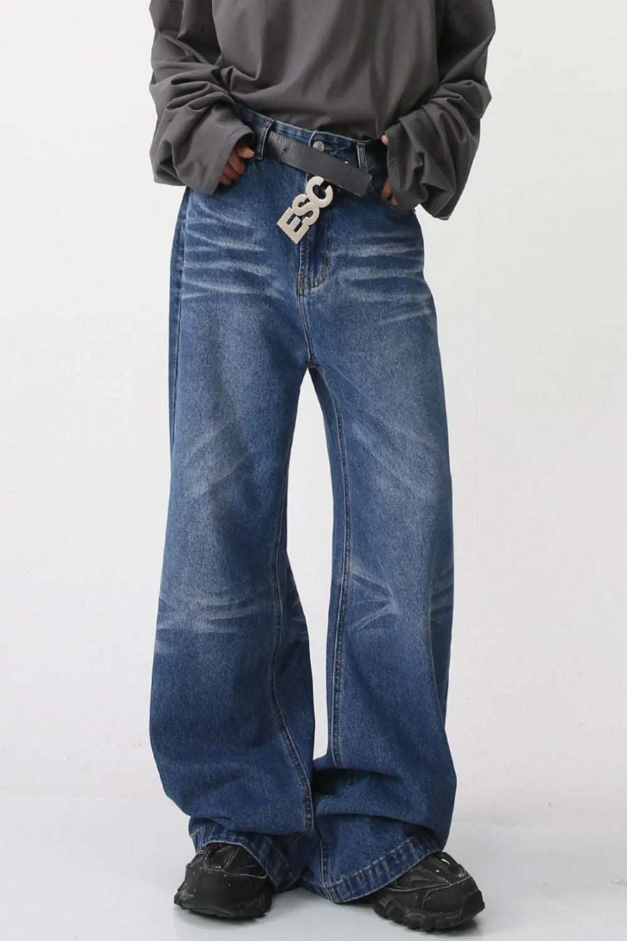 Wide-leg distressed denim trousers in medium wash with a relaxed fit.