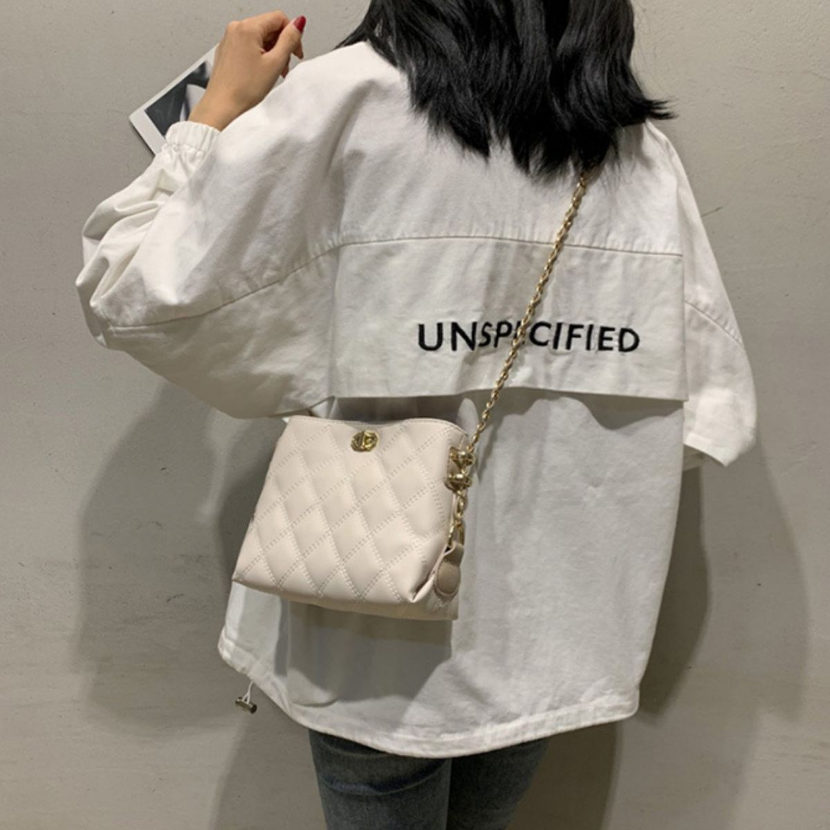 White quilted crossbody bag with diamond pattern and gold chain strap