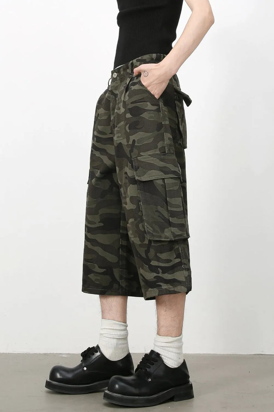 Pleated camo culotte cargo shorts in green camouflage with multiple pockets.