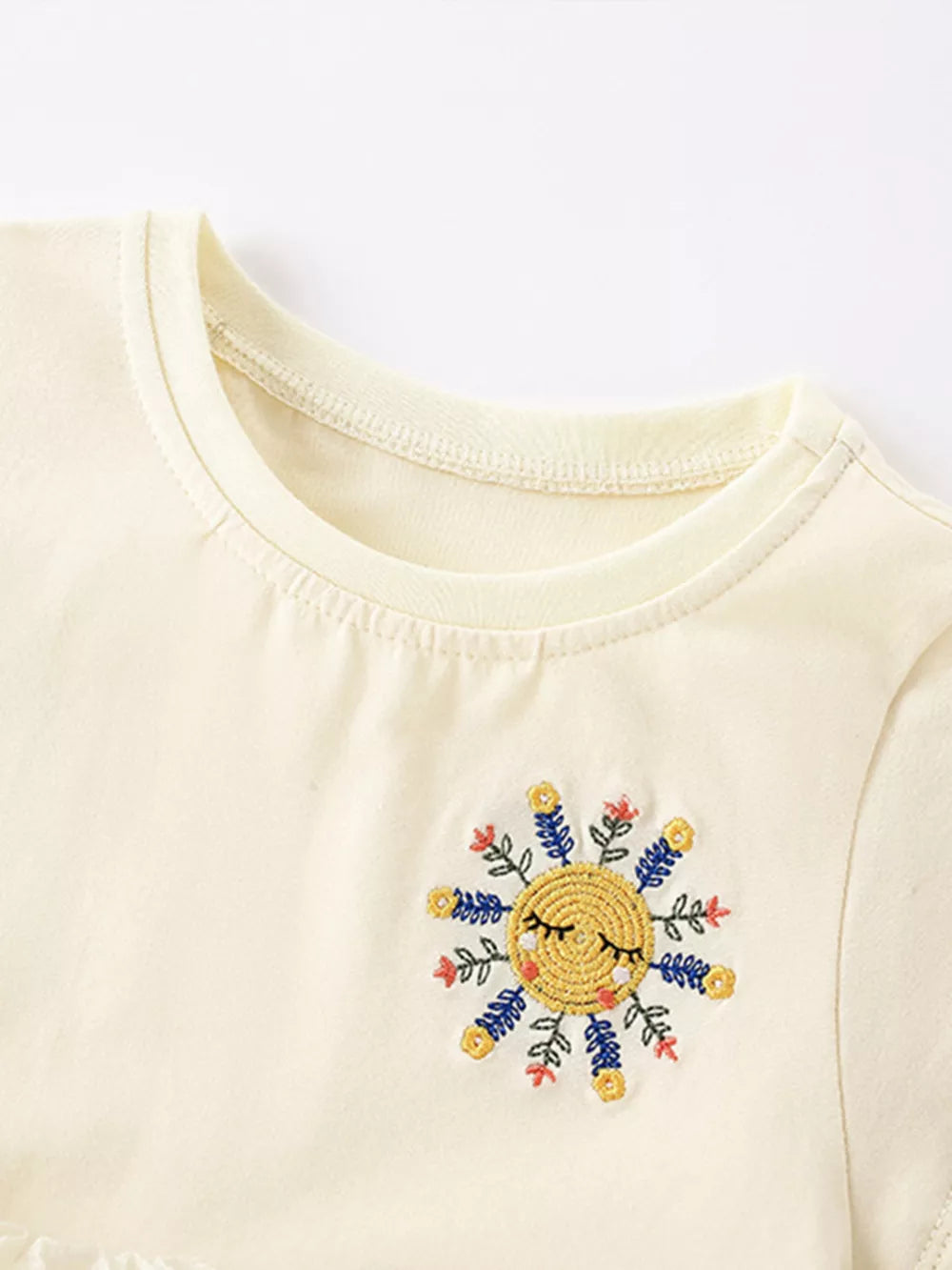 Cream cotton toddler dress with embroidered sun detail