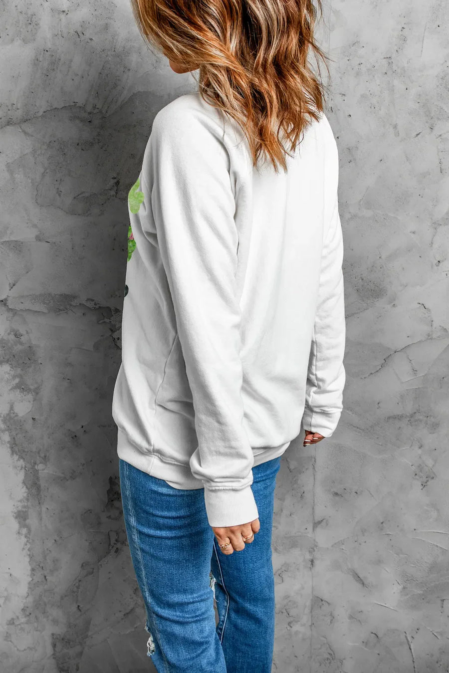White crewneck sweatshirt with a clover print and long sleeves.