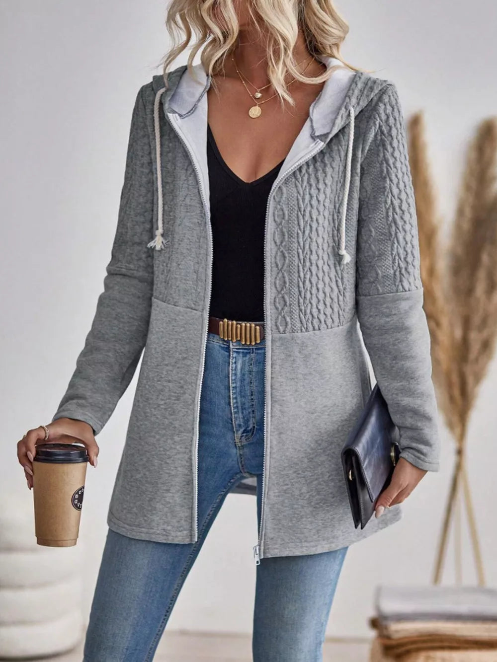 Grey cable-knit hooded zip jacket with contrast jersey panels.