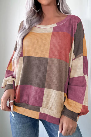 Multicolor patchwork waffle knit top with round neckline and long sleeves.