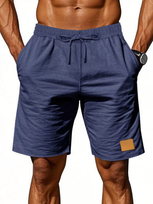 Navy blue chino shorts with drawstring waist and leather patch detail.