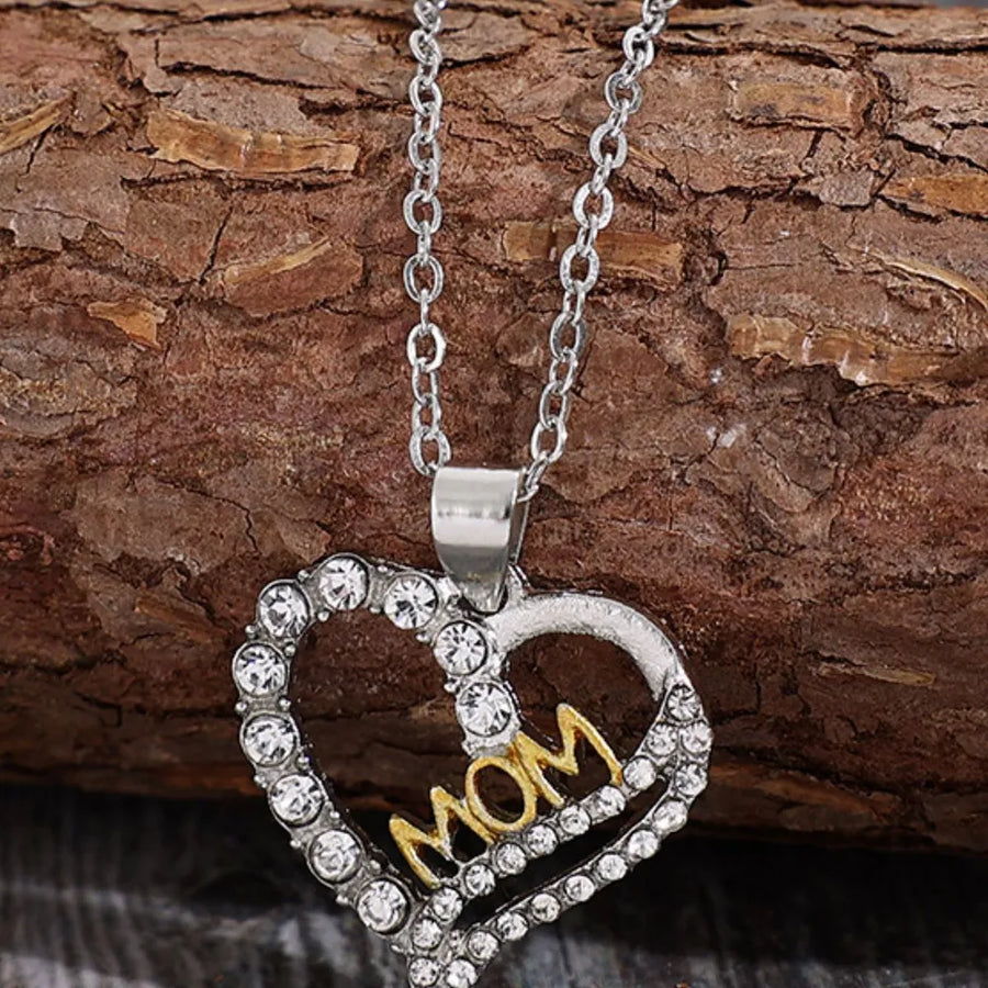 Silver heart necklace with MOM in gold and crystal accents.
