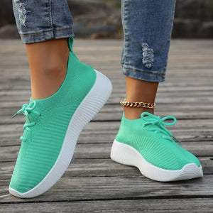 Light green breathable lace-up sneakers with white mid sole and white laces.