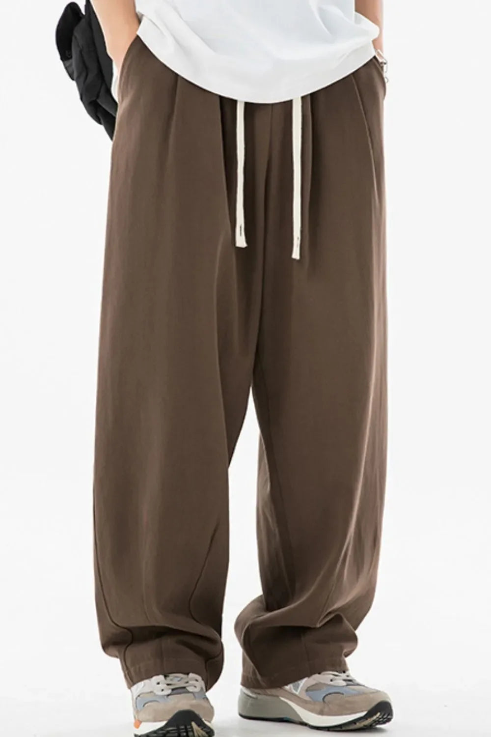 Wide-leg pleated drawstring trousers in coffee brown with a relaxed fit.