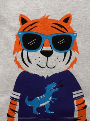 Toddler t-shirt with a grey cotton crew neck, featuring a tiger graphic wearing blue sunglasses and a blue dinosaur graphic.