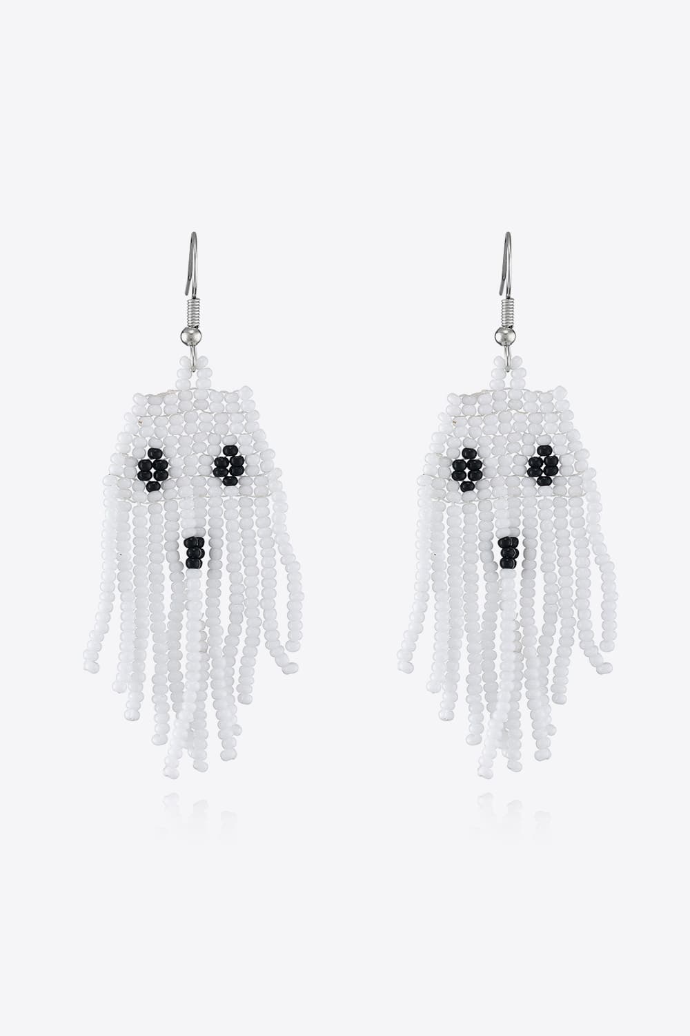 White beaded ghost fringe earrings with black bead eyes and mouth.