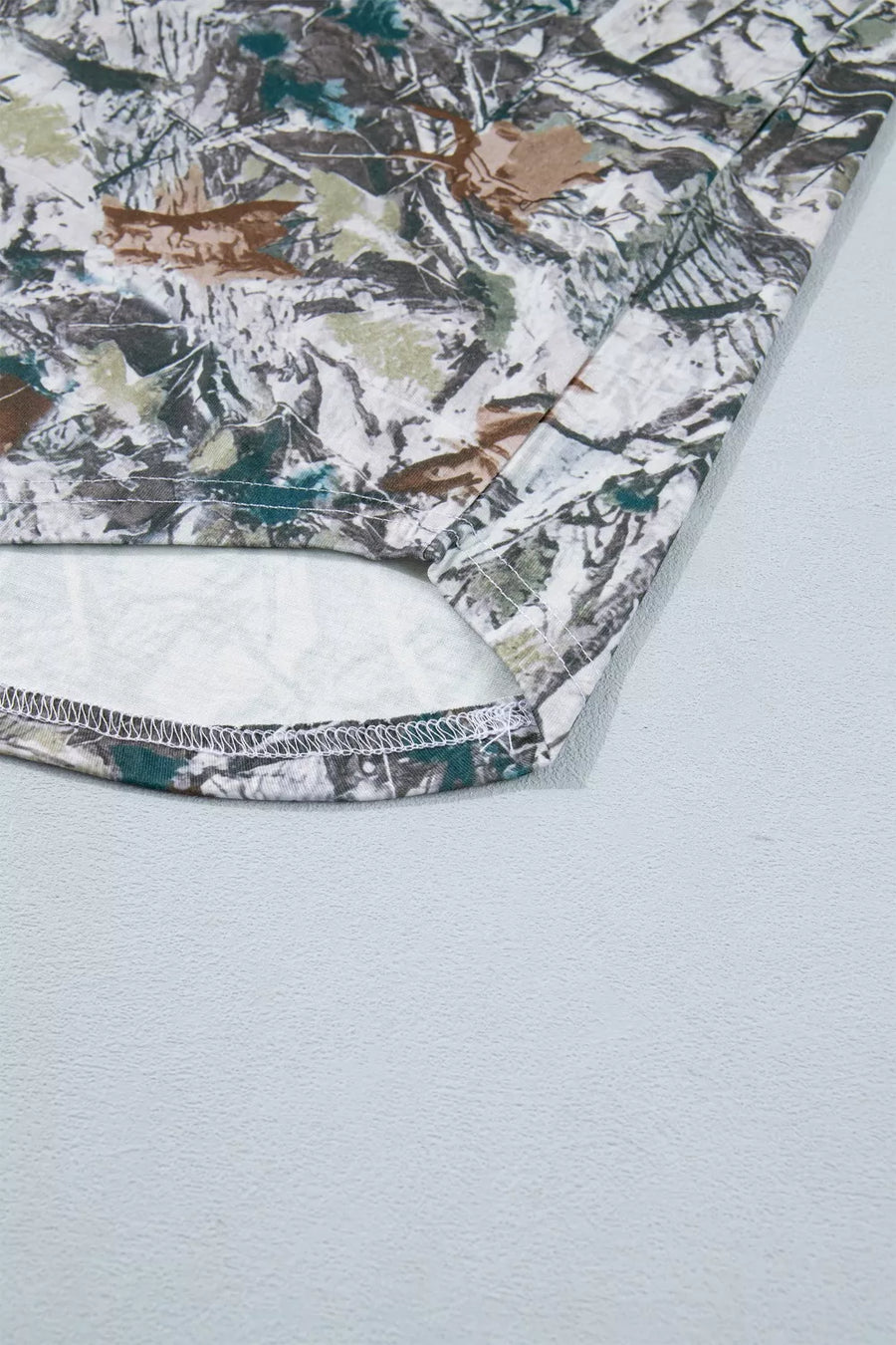 Earthy camouflage print henley t-shirt with a detailed hem.