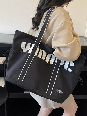 Black drawstring shoulder bag with bold white lettering and white stripe details.
