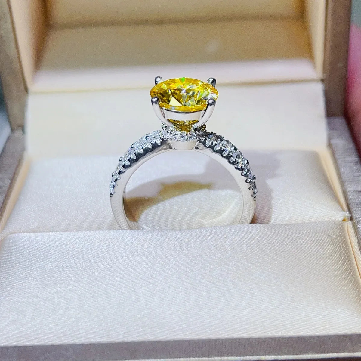 Yellow moissanite pavé band ring with a large center stone in a silver setting.