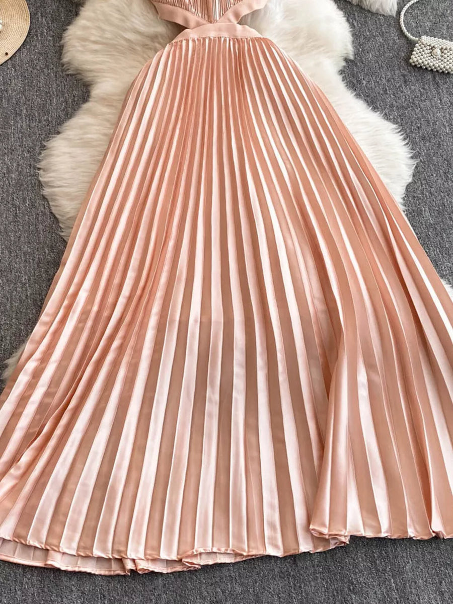 Elegant peach pleated maxi dress with cutout detail and a satin finish.