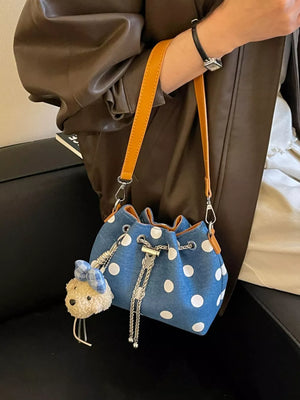 white crossbody bag featuring adjustable strap and polka dot