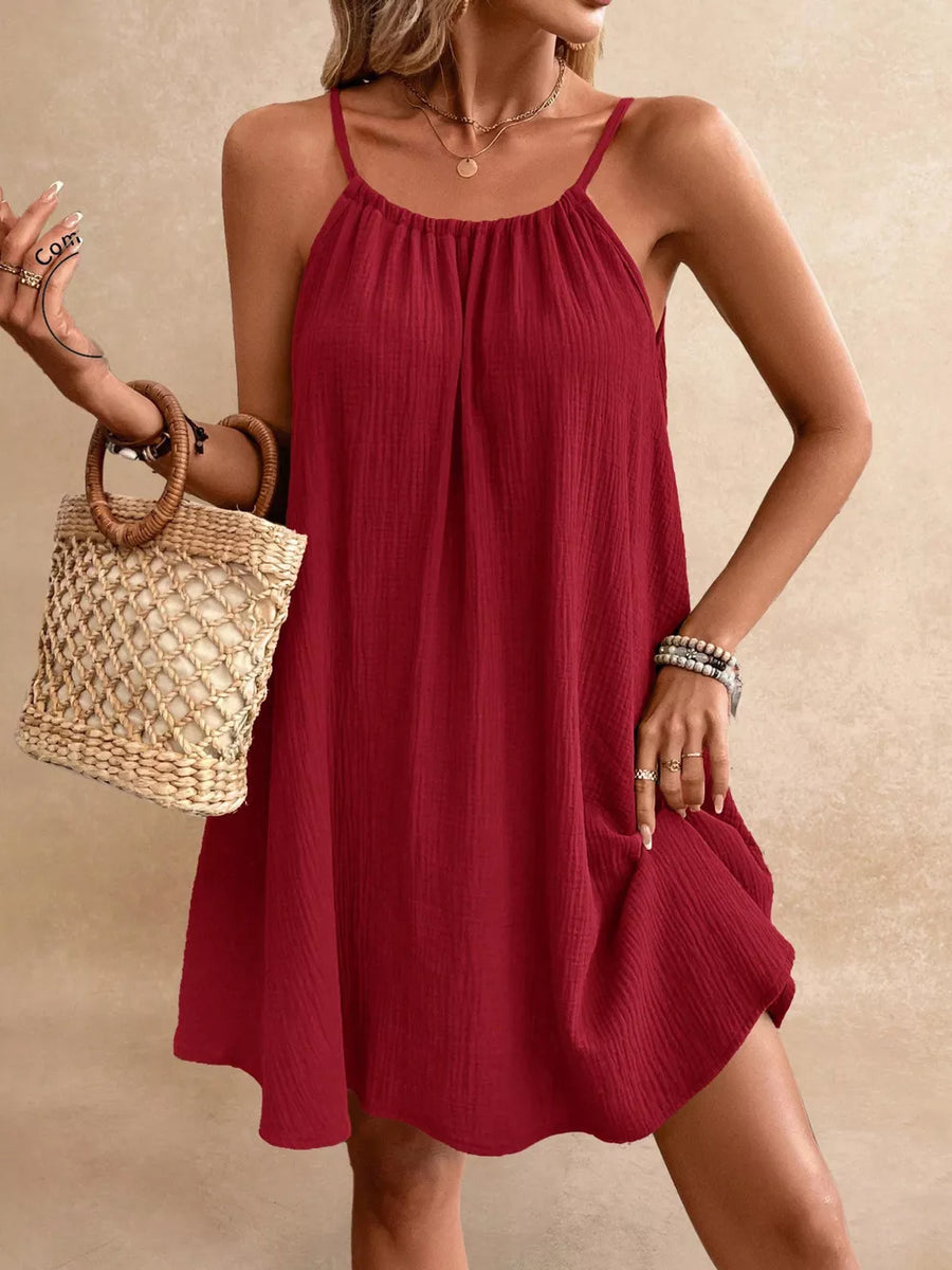 Red spaghetti strap gauze dress with gathered neckline and textured fabric.
