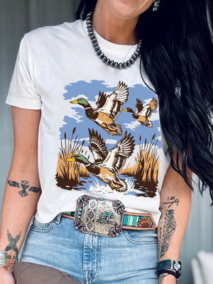 White cotton tee with a graphic of mallard ducks flying over reeds and water.