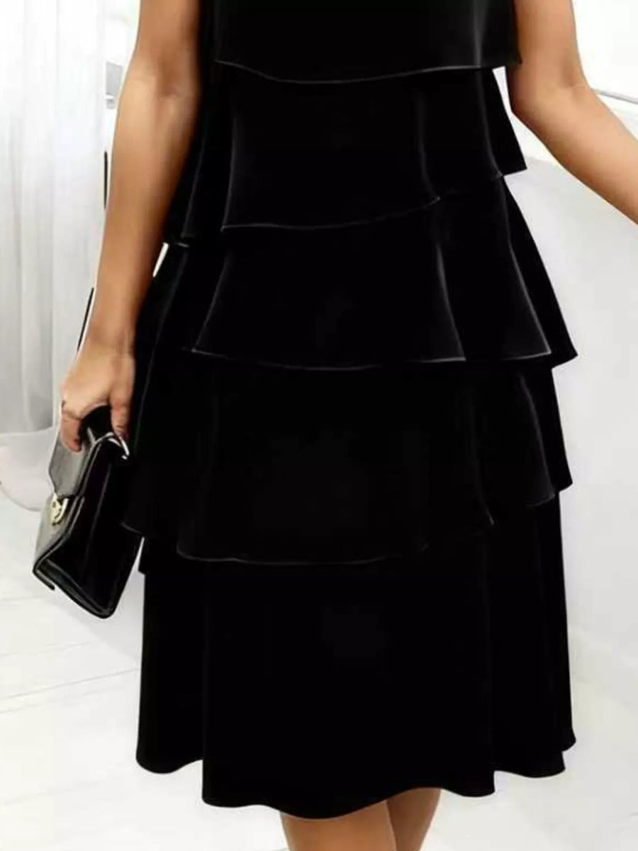 Black tiered ruffle dress with petal sleeves and a feminine fit.