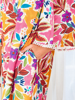 Print bell sleeve mini dress with colorful floral pattern and pom-pom trim detail.