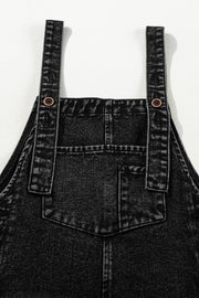 Black denim culotte overalls with distressed details and button straps.