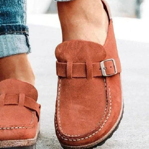 Suede buckle mule loafers in caramel with white stitching detail.